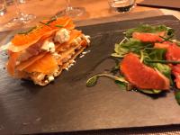 Un plato negro con un sándwich y una ensalada. en Le Relais de la Chouette, en Berson