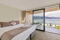 ein Schlafzimmer mit großem Bett und großem Fenster in der Unterkunft Falcon&#39;s View Queenstown in Queenstown