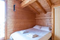 a bedroom with a bed in a wooden cabin at Chalet Le Lapye in Les Gets