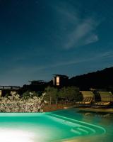 a swimming pool at night with a building in the background at Encuentro Guadalupe in Valle de Guadalupe
