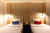two beds sitting next to each other in a room at Ever Delightful Business Hotel in Chiayi City