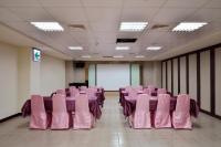 a conference room with pink chairs and a white screen at Ever Delightful Business Hotel in Chiayi City