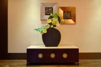 a black vase with flowers on top of a table at Ever Delightful Business Hotel in Chiayi City