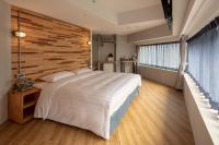 a bedroom with a large bed and a wooden wall at RF Hotel - Zhongxiao in Taipei