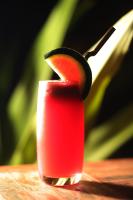 Een mes snijdt in een rode drank. bij Dontrei Villa Angkor in Siem Reap