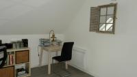 a desk with a chair in a room with a window at Location Tromeal Lasalle in Saint-Pol-de-Léon