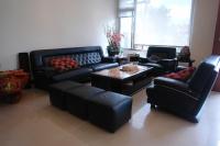 a living room with black leather furniture and a table at Hualien Sheraton Hostel in Hualien City