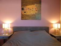 a bedroom with a bed with two lamps and a painting at Le Sud sur Plage in Mèze