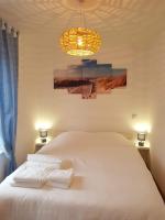 a bedroom with a white bed and a chandelier at Iliade in Rue