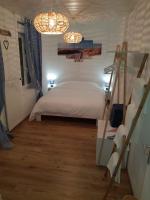 a bedroom with a bed with a ladder and two lights at Iliade in Rue