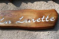 a wooden sign that says la junta sitting on the floor at VILLA LA LURETTE, appartement et studio in Saint-Étienne-les-Orgues