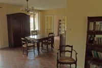 a dining room with a wooden table and chairs at VILLA LA LURETTE, appartement et studio in Saint-Étienne-les-Orgues