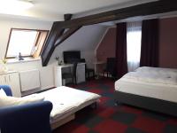 a hotel room with two beds and a desk at Hotel Luca in Betzenstein