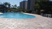 a swimming pool in a resort with a stone patio at Golden Dolphin Express in Caldas Novas