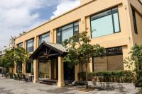 a yellow building with trees in front of it at The Loft Seaside Suites in Jinshan