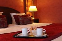 a tray with two coffee cups on a bed at Hotel Le Mandelberg in Mittelwihr