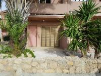 una casa rosa con palmeras delante en Ariadne apt 103 -300m from Lighthouse beach, en Pafos