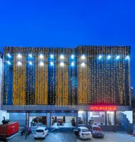 Un edificio con coches aparcados en un estacionamiento. en Trimrooms Mount Blue, en Jaipur