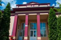 a pink building with trees in front of it at Pensiunea Splendid in Dorohoi