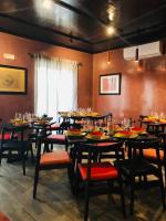 een eetkamer met tafels en stoelen en een raam bij villa oltremare resort in Bagheria