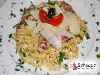 a white plate of pasta with tomatoes and cheese at Amigo Hotel in Sulejówek