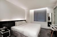 a bedroom with a large white bed and a window at CityInn Hotel Plus - Taichung Station Branch in Taichung