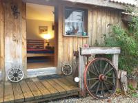 a wooden cabin with a wooden wheel in front of it at Chrom Ranch Reiterhof in Memmingen