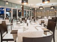 Crvena Luka Resort في بيوغراد نا مورو: غرفة طعام مع طاولات وكراسي ونوافذ