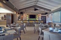 卡拉马孔Ionion Blue Hotel Zante的配有桌椅和平板电视的餐厅