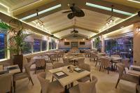 卡拉马孔Ionion Blue Hotel Zante的餐厅配有桌椅和吊扇