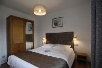 1 dormitorio con 1 cama grande y cabecero de madera en RESIDENCE LE SPLENDID, en Villard-de-Lans