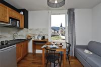 cocina y sala de estar con mesa y sofá en RESIDENCE LE SPLENDID, en Villard-de-Lans