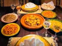 een tafel met borden met eten en glazen wijn bij Riad Selouane in Marrakesh