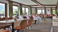 a dining room with tables and chairs and windows at DEVA Hotel Renchtalblick in Oberkirch