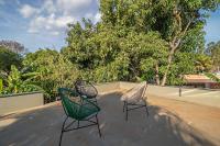two chairs sitting on a roof with trees in the background at Suítes no Quintal in Brotas