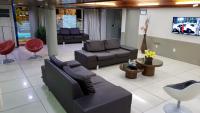 a living room with couches and chairs and a tv at JR Hotel in João Pessoa