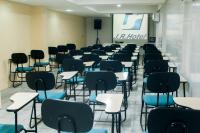 a classroom with desks and chairs in a room at JR Hotel in João Pessoa