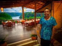 una mujer parada en el porche de un restaurante en Tufi Resort, en Tufi