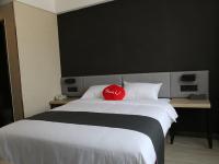 almohada roja en una cama en una habitación de hotel en Thank Inn Plus Hotel Shandong Qufu Kongfu, en Jining