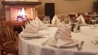 een tafel met borden en servetten erop met een open haard bij Hotel Garden Club in Braşov