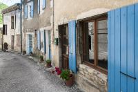 a building with blue doors and flowers on a street at Les Hirondelles in Pont-de-Barret