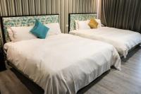 two beds sitting next to each other in a room at The Loft Seaside Suites in Jinshan