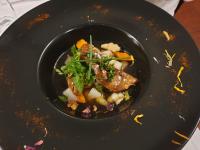 un tazón negro de comida con carne y verduras en Logis Domaine de Peyrolade, en Daux