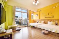 a bedroom with two beds and a large window at Piau Po 21 Inn in Taitung City