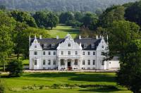 a large white house on a lush green field at Kokkedal Slot Copenhagen in Hørsholm