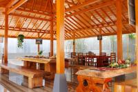 a pavilion with wooden tables and benches in a restaurant at Pavilla Labuan Bajo in Labuan Bajo