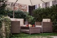 a group of wicker chairs and a table with an umbrella at Hotel Pausania in Venice