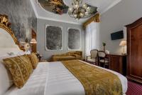 a bedroom with a large bed with a chandelier at Hotel Pausania in Venice