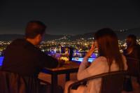 een groep mensen die 's nachts aan een tafel zitten bij Domus Lake Resorts in Villa Carlos Paz