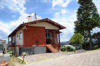 a small house with a porch and stairs on a street at Pousada Colina Da Neve in São Joaquim